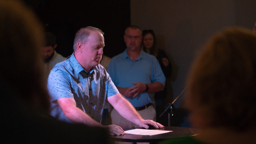 Pastor Steven Parsley praying during a Sunday gathering